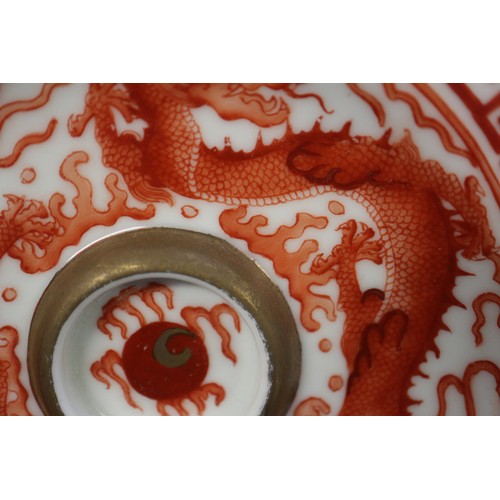 78 - A pair of Chinese iron red and white glazed tea bowls and saucers, decorated dragons and flaming pea... 