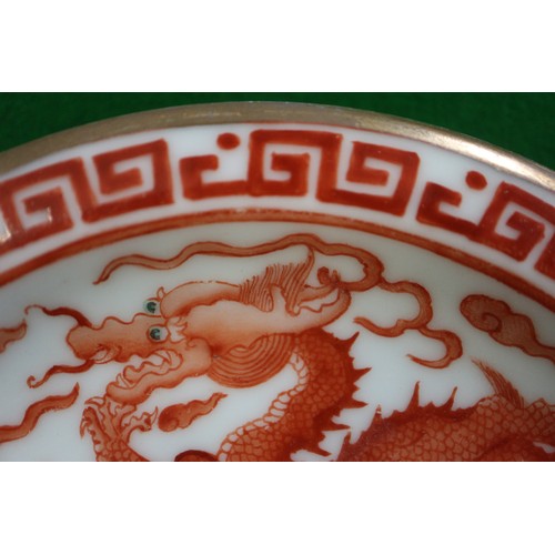 78 - A pair of Chinese iron red and white glazed tea bowls and saucers, decorated dragons and flaming pea... 