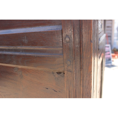 408 - An 18th century carved oak wardrobe enclosed two panelled doors with serpent hinges, on stile suppor... 