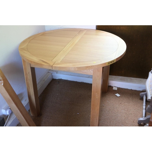 459 - A light oak circular extending dining table, on square supports, 42