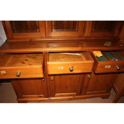 538 - A Ducal pine dresser, the upper section enclosed three glazed panel doors over three drawers and cup... 