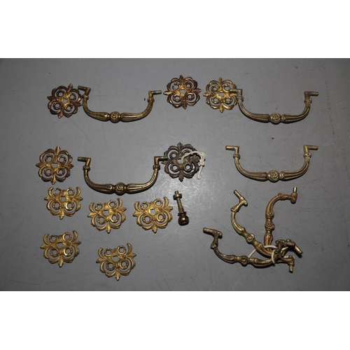 127 - A set of four mid 18th century ormolu commode handles with floral cross back plates and a similar se... 