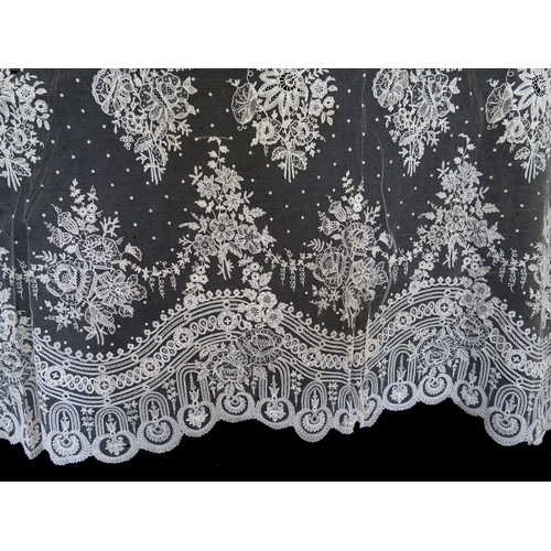 171 - A late 19th century Brussels lace applique skirt overlay flounce, the bobbin lace design edged with ... 