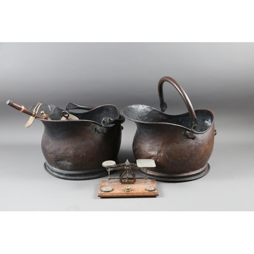 131 - Two copper coal helmets, three fire implements, and a brass letter balance and weights