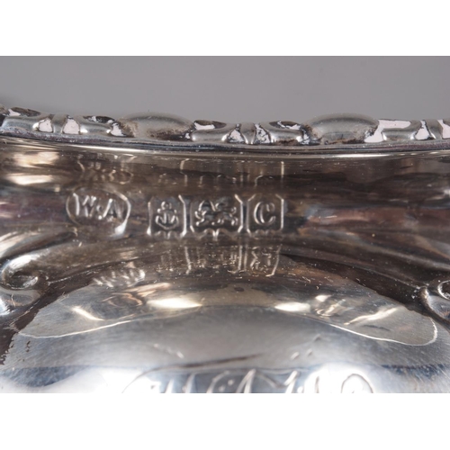 249 - A pair of silver salt cellars with embossed decoration, a silver lobed bonbon dish and a silver napk... 