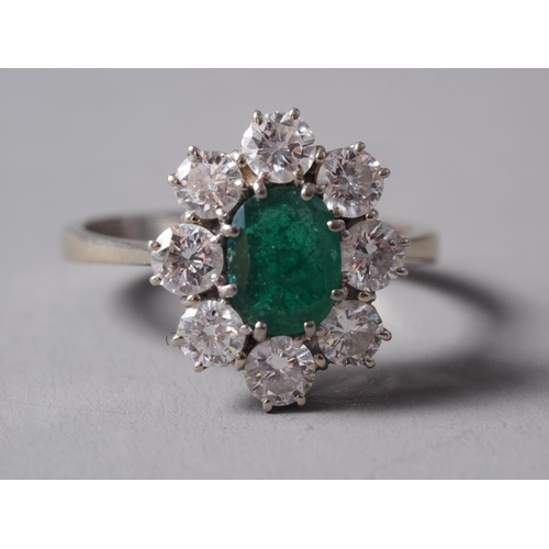 268 - An 18ct white gold, emerald and diamond cluster ring, set central oval emerald surrounded eight bril... 