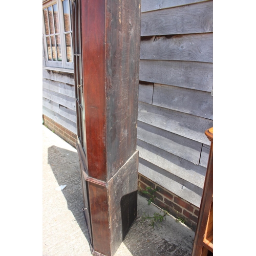 392 - A 19th century mahogany floor standing corner cupboard, the upper section enclosed glazed door over ... 