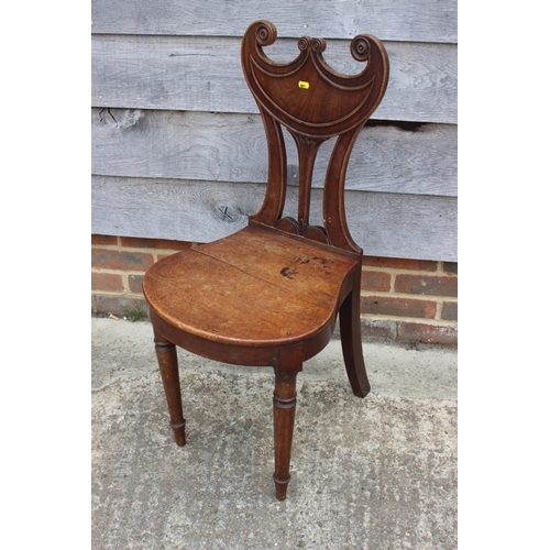 415 - A 19th century mahogany scroll back hall chair with panel seat and turned supports