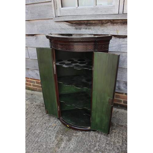 425 - A 19th century figured mahogany and inlaid bowfront hanging corner cupboard with dentil cornice and ... 