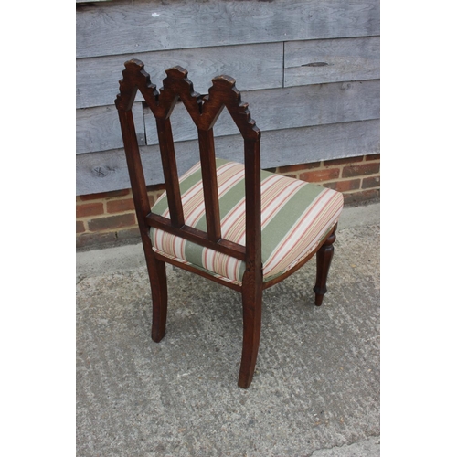 429 - A carved oak gothic design side chair with triple arch back, seat upholstered in a striped fabric, o... 