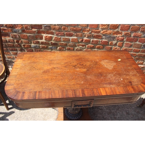 444 - A rosewood and banded fold-over tea table, on carved column and quadraform base with lion paw feet, ... 