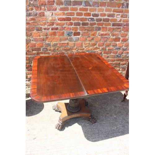 444 - A rosewood and banded fold-over tea table, on carved column and quadraform base with lion paw feet, ... 