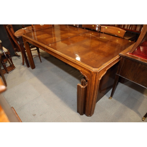 483 - An American figured walnut and banded extending dining table with two extra leaves, on square suppor... 