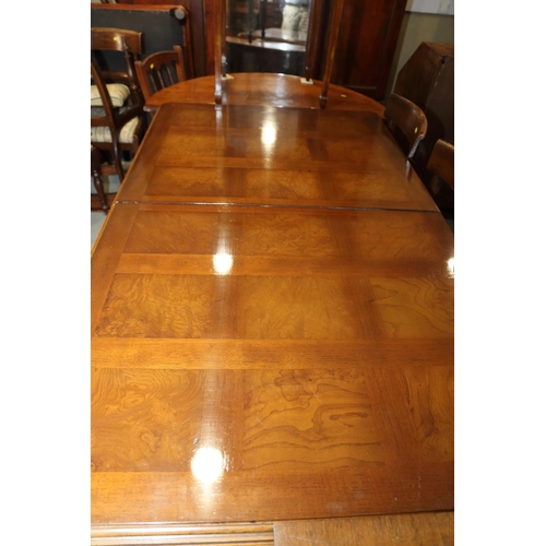 483 - An American figured walnut and banded extending dining table with two extra leaves, on square suppor... 