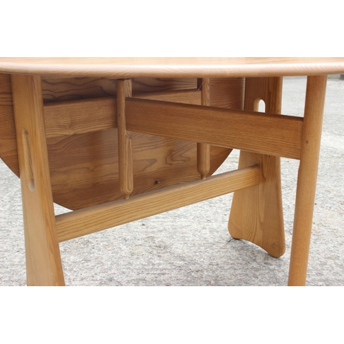 492 - An Ercol ash oval drop leaf dining table, on gateleg supports, 42