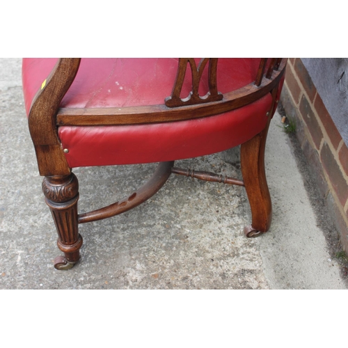 498 - An oak and red studded leather tub chair with pierced splats, fluted supports and crinoline stretche... 