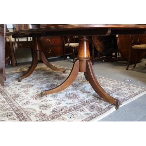 519 - A mahogany double pedestal dining table of Georgian design with two extra leaves, 144