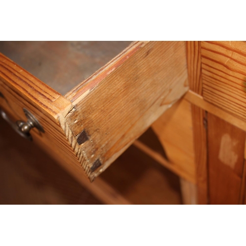 540 - A waxed pine dresser, fitted shelves over three drawers, dog kennel and flanking cupboards, on block... 