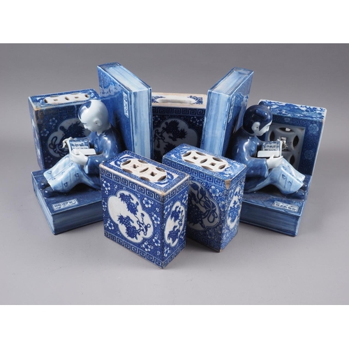 78 - A pair of Chinese blue and white pottery book ends, formed as figures reading, 8 3/4