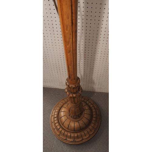 216 - A polished as walnut and carved standard lamp, on circular base