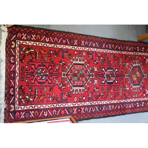 553 - A Hamadan runner with star medallions on a red ground, 150