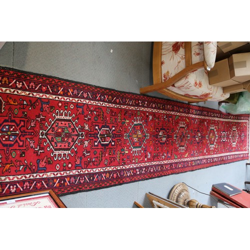 553 - A Hamadan runner with star medallions on a red ground, 150