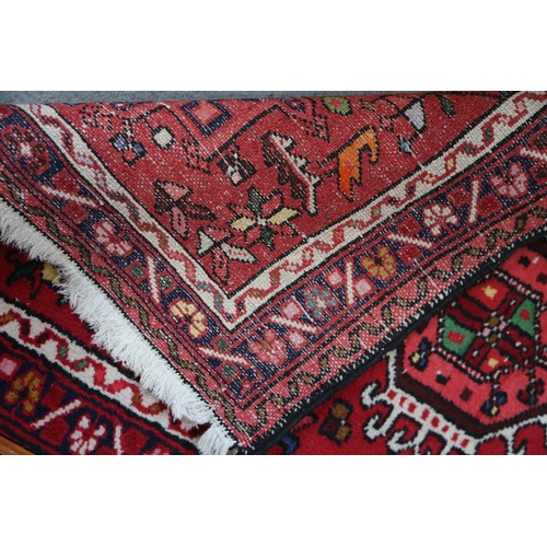 553 - A Hamadan runner with star medallions on a red ground, 150