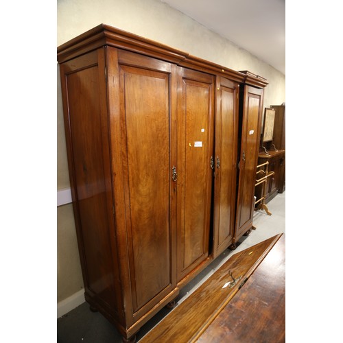 430 - A 19th century French walnut inverse breakfront wardrobe enclosed four panel doors, on turned suppor... 