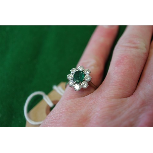 268 - An 18ct white gold, emerald and diamond cluster ring, set central oval emerald surrounded eight bril... 