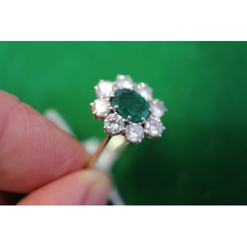 268 - An 18ct white gold, emerald and diamond cluster ring, set central oval emerald surrounded eight bril... 