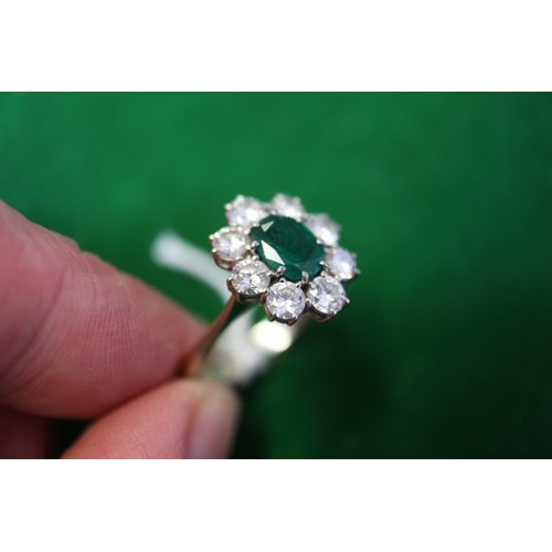 268 - An 18ct white gold, emerald and diamond cluster ring, set central oval emerald surrounded eight bril... 