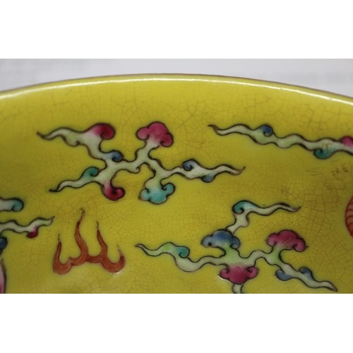 64 - A Chinese dish, decorated with a dragon, flaming pearl and phoenix, on a yellow ground, seal mark to... 