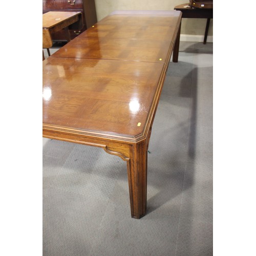 483 - An American figured walnut and banded extending dining table with two extra leaves, on square suppor... 