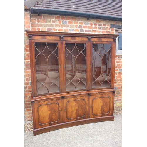 426 - A figured mahogany concave bookcase of Georgian design enclosed three Gothic glazed panel doors over... 