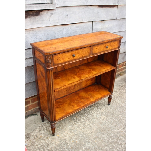 427 - A Theodore Alexander burr walnut bookcase of Louis XVI design, fitted two drawers over open shelves,... 