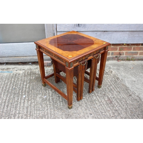 434 - A mahogany and ash banded nest of three occasional table, on reeded supports and brass feet, 20