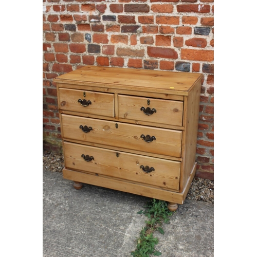 450 - A waxed pine chest of two short and two long drawers with brass handles, on turned supports, 36