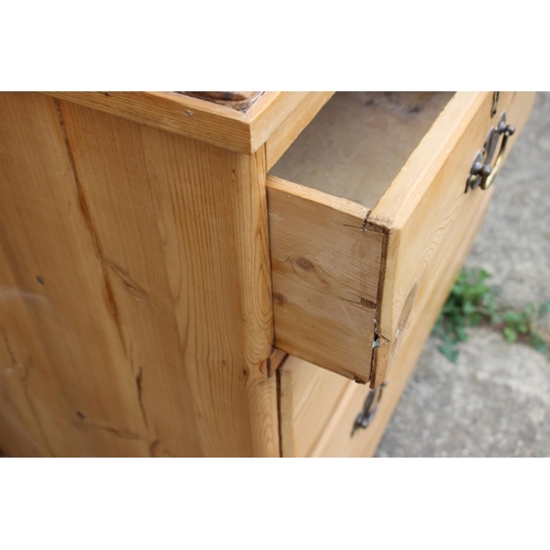 450 - A waxed pine chest of two short and two long drawers with brass handles, on turned supports, 36