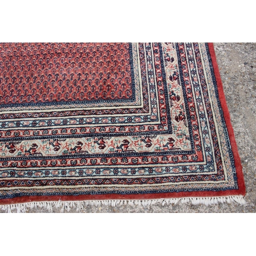 456 - A Persian carpet with all-over boteh design on a red ground, multi-bordered in shades of blue, red, ... 