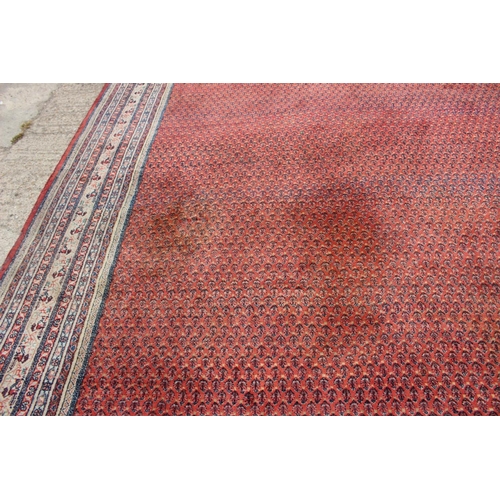 456 - A Persian carpet with all-over boteh design on a red ground, multi-bordered in shades of blue, red, ... 