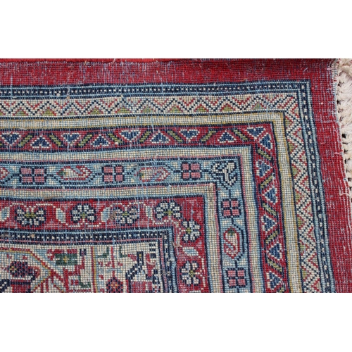 456 - A Persian carpet with all-over boteh design on a red ground, multi-bordered in shades of blue, red, ... 