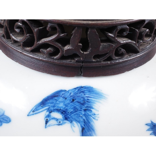 91 - A Chinese blue and white floral bird decorated pot-pourri jar with pierced hardwood cover and stand,... 