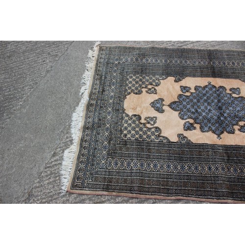 455 - A Middle Eastern rug with central medallion and multi-borders in shades of natural and grey, 48