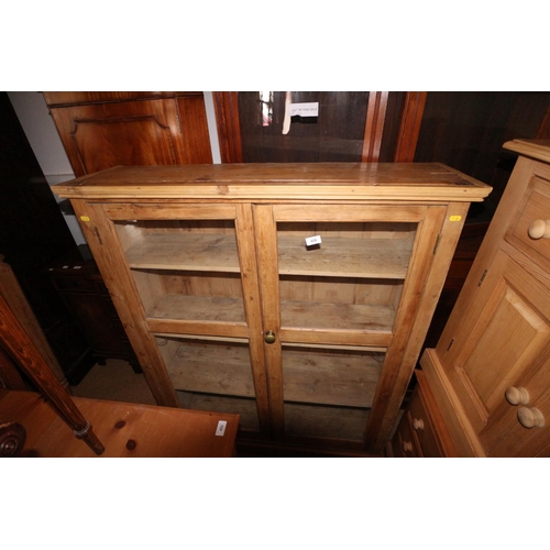 439 - A 19th century waxed pine side cabinet enclosed two glazed doors, 41 1/2