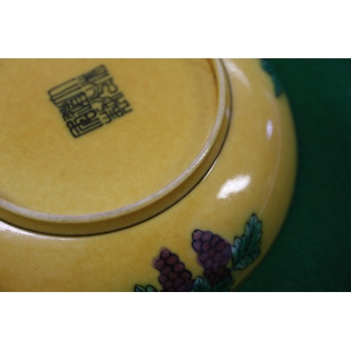 72 - A Chinese yellow glazed dish with two dragons and reverse decorated with grapes, seal mark to base, ... 