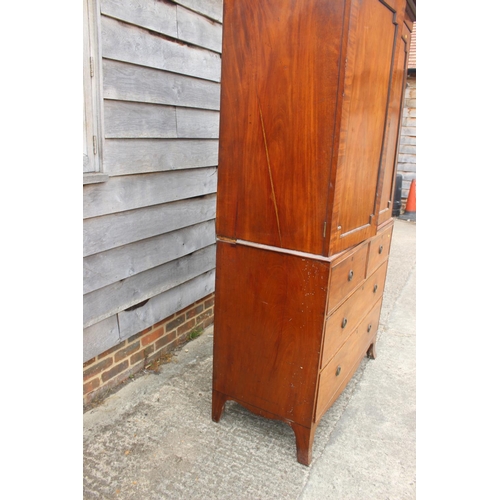 411 - An early 19th century mahogany linen press, the upper section enclosed two doors, over two faux draw... 