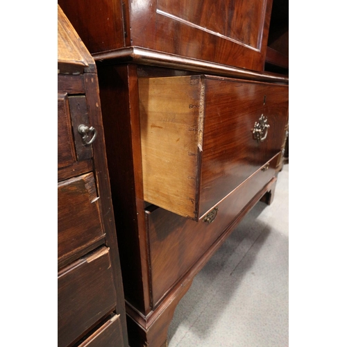 412 - An early 19th century mahogany linen press, the upper section fitted trays enclosed two doors, over ... 