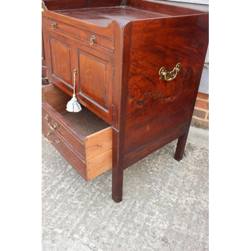 414 - A Georgian mahogany tray top bedside stand, fitted drawer over cupboards and deep drawer, on moulded... 