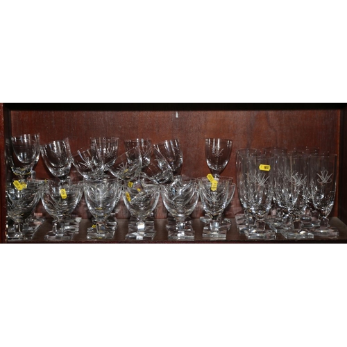 22 - A quantity of clear table glass with engraved decoration, on square bases