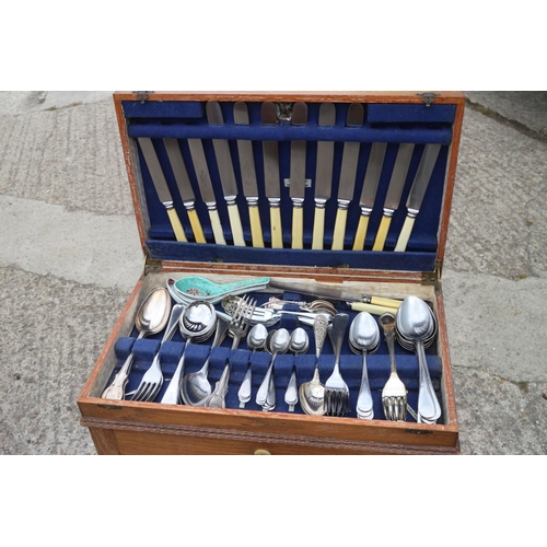 220 - An incomplete set of silver plated cutlery, in an oak two-tier canteen, on barley twist supports